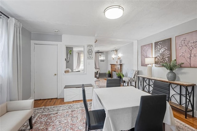 dining area with a textured ceiling and light hardwood / wood-style flooring