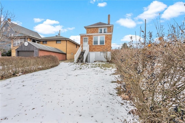 snow covered property with a garage