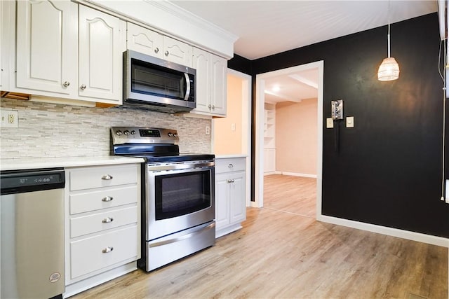 kitchen featuring pendant lighting, light hardwood / wood-style flooring, appliances with stainless steel finishes, white cabinetry, and decorative backsplash