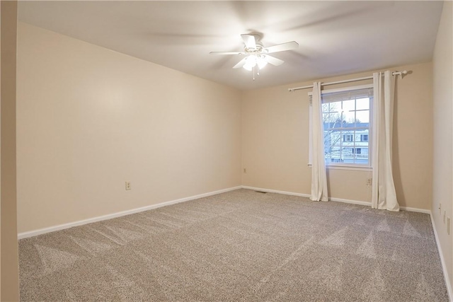 carpeted spare room featuring ceiling fan