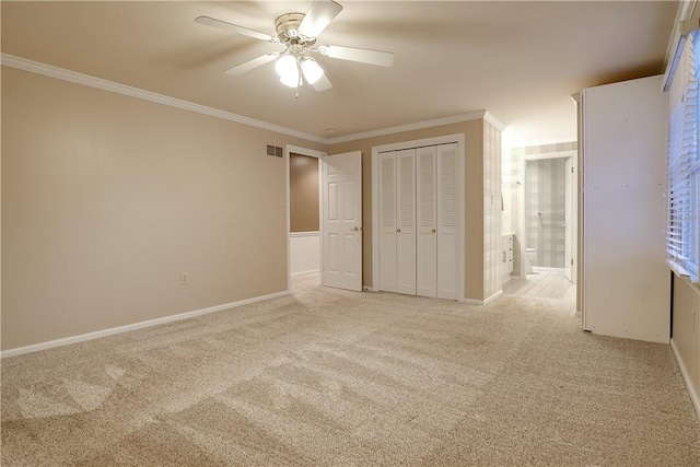 unfurnished bedroom with light colored carpet, ensuite bath, ornamental molding, and a closet