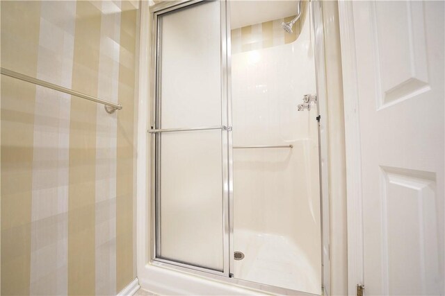 bathroom with a shower with door