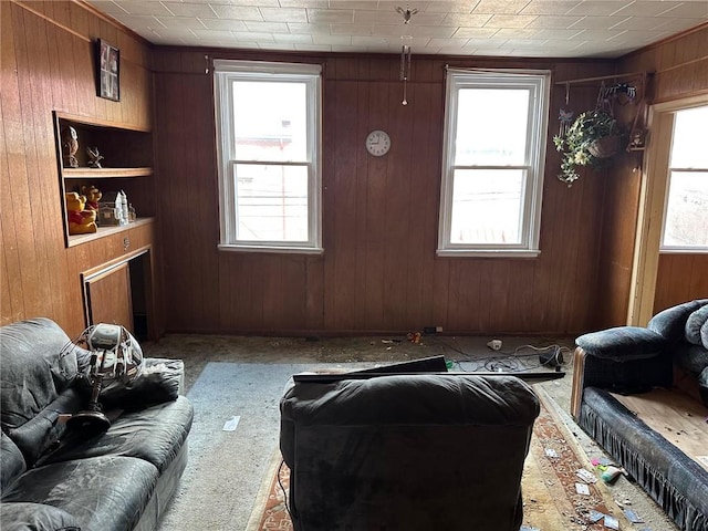 carpeted living room with wood walls