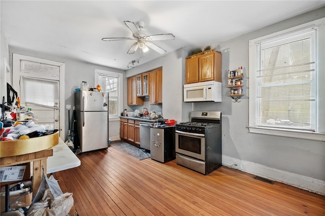 kitchen with ceiling fan, stainless steel appliances, and light wood-type flooring