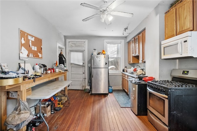 kitchen featuring stainless steel appliances, ceiling fan, and dark hardwood / wood-style flooring