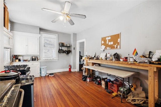 interior space with ceiling fan, light hardwood / wood-style flooring, and white cabinets