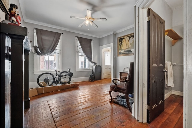 sitting room with dark hardwood / wood-style flooring, ornamental molding, and ceiling fan