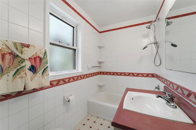 bathroom featuring vanity, tiled shower / bath combo, and tile walls