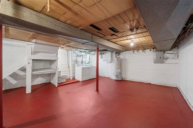 basement featuring gas water heater, electric panel, and washing machine and clothes dryer