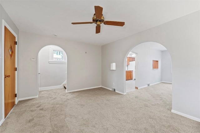 spare room with ceiling fan and light colored carpet