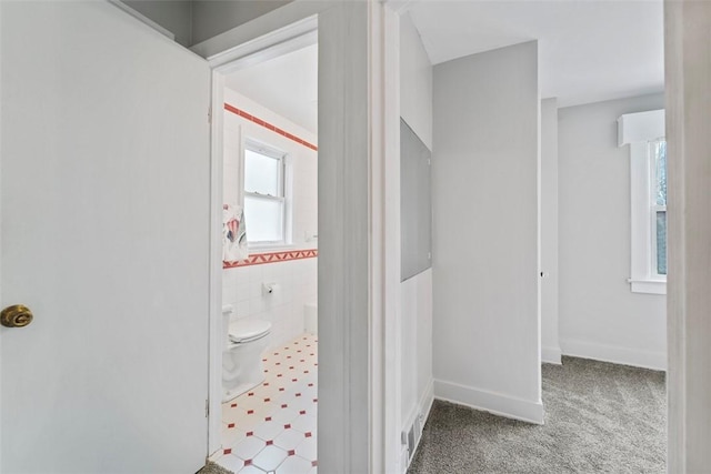 bathroom featuring tile walls and toilet