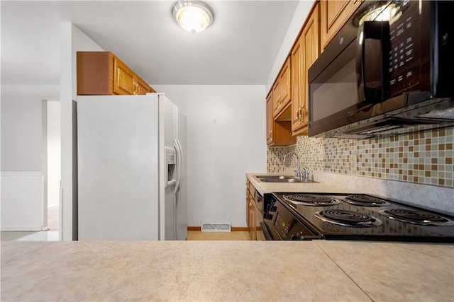 kitchen with tasteful backsplash, sink, and black appliances