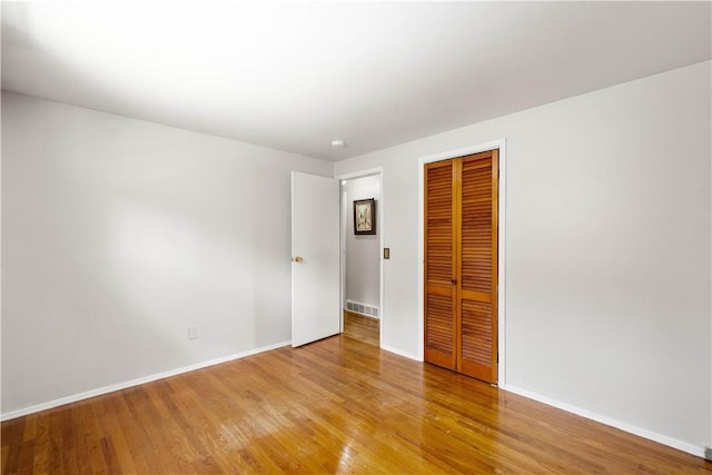 unfurnished bedroom with light hardwood / wood-style flooring and a closet