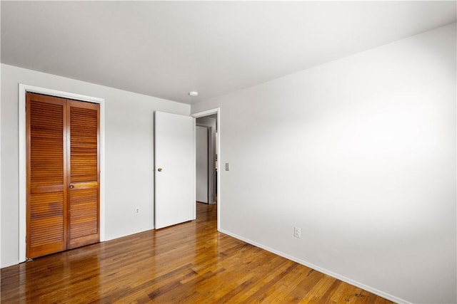 unfurnished bedroom with wood-type flooring and a closet