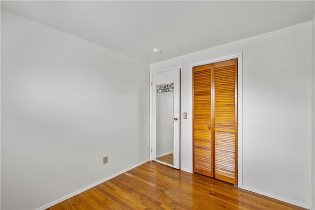 unfurnished bedroom featuring wood-type flooring and a closet