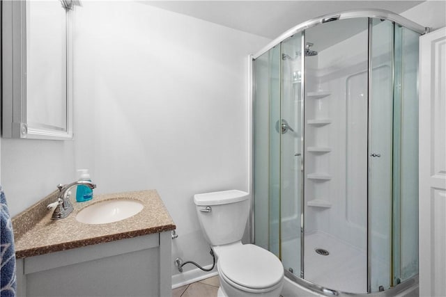 bathroom featuring vanity, tile patterned flooring, a shower with shower door, and toilet