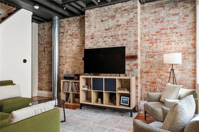 living room featuring brick wall and wood-type flooring