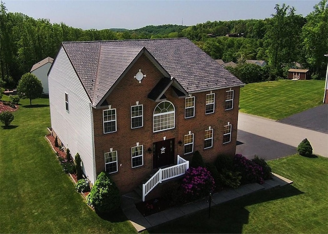 colonial inspired home featuring a front lawn