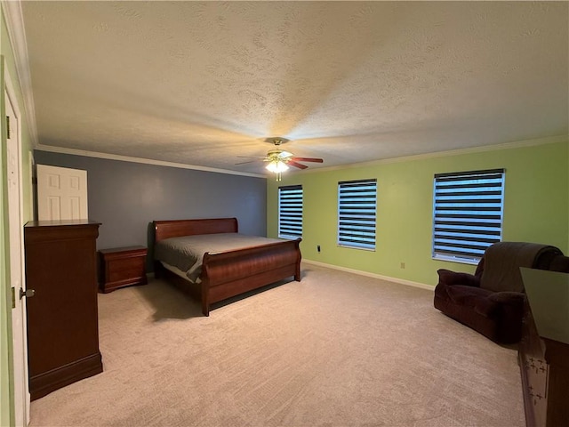 carpeted bedroom featuring ornamental molding, ceiling fan, and a textured ceiling