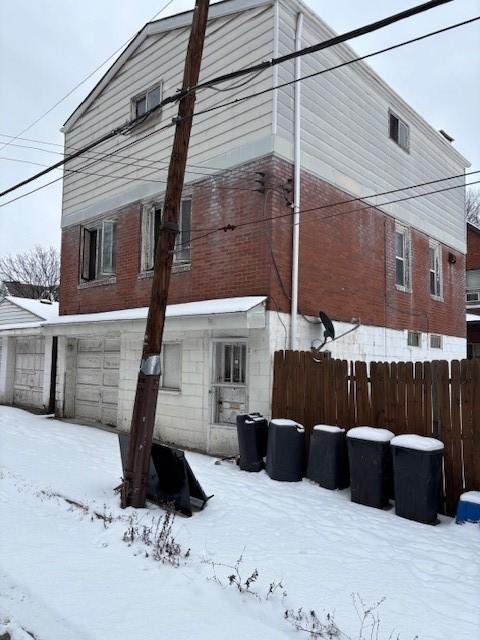 view of snow covered rear of property