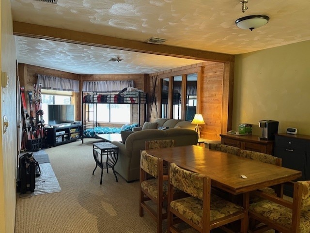 carpeted dining space featuring a textured ceiling