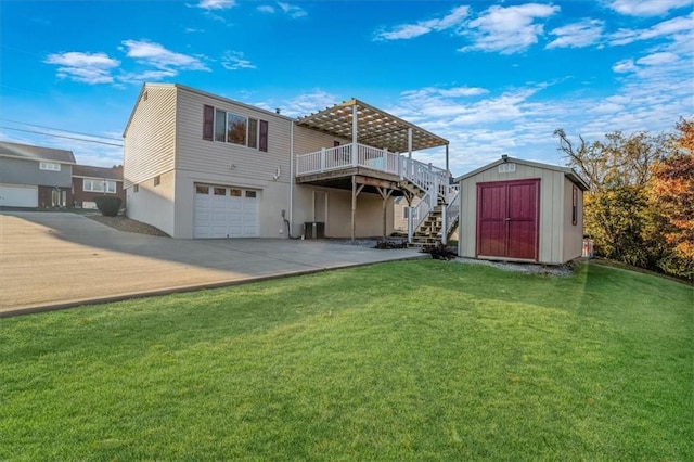 back of property with a wooden deck, a garage, a yard, and a storage unit