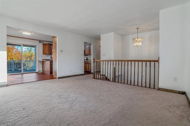 carpeted spare room with a notable chandelier