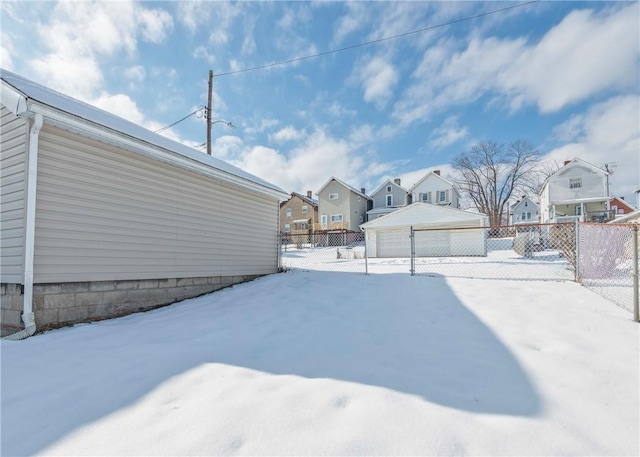 yard covered in snow with a garage and an outdoor structure