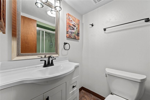 bathroom with vanity, an enclosed shower, and toilet