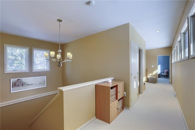 hall featuring a chandelier and carpet