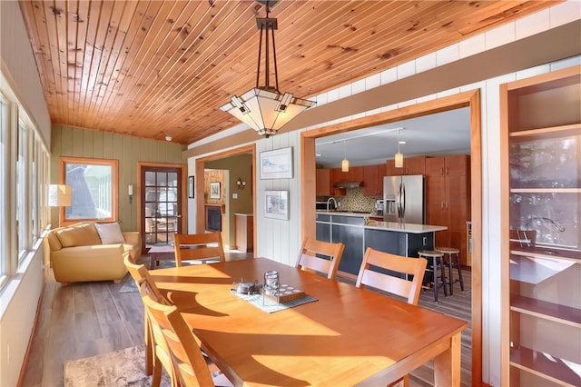 dining area featuring wood-type flooring and wooden ceiling