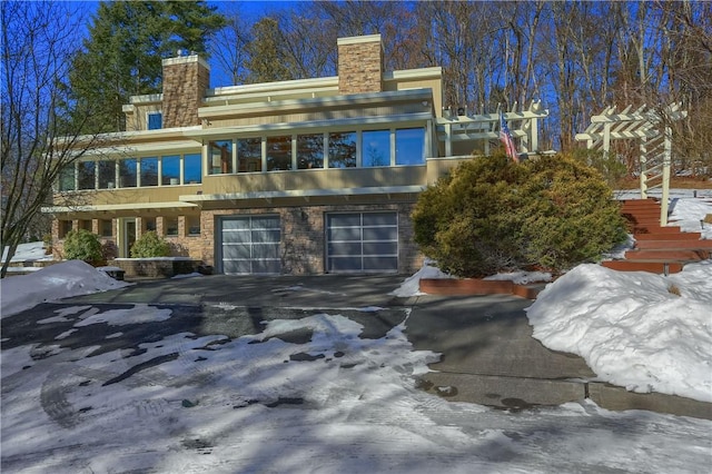 snow covered property with a garage