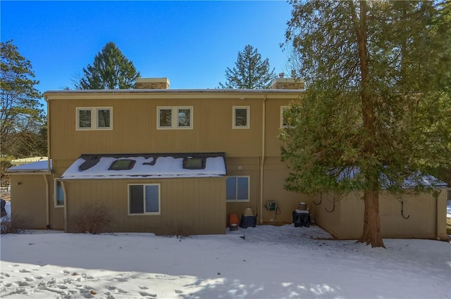 view of snow covered rear of property