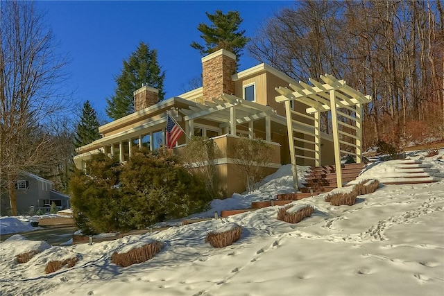 view of snowy exterior featuring a pergola