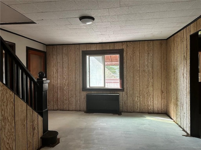 interior space featuring radiator heating unit and wood walls