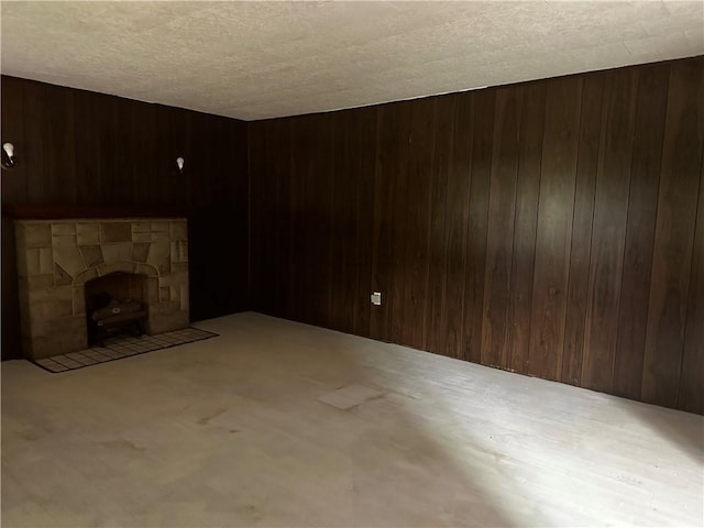 unfurnished living room with a textured ceiling and wood walls