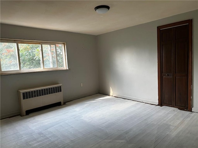 spare room with radiator and light hardwood / wood-style flooring