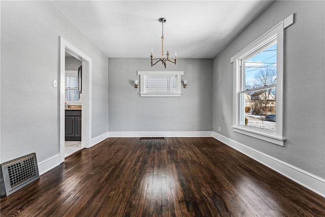 unfurnished dining area featuring hardwood / wood-style floors and a notable chandelier