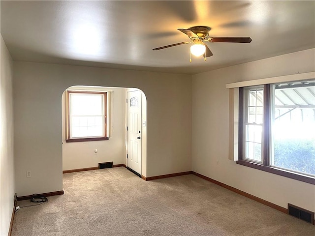 carpeted spare room with ceiling fan and a healthy amount of sunlight