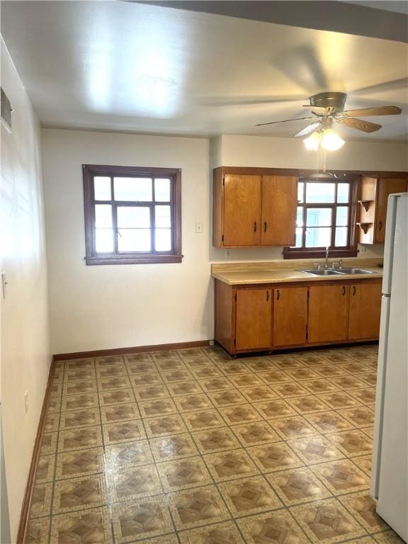 kitchen with a healthy amount of sunlight, white fridge, sink, and ceiling fan