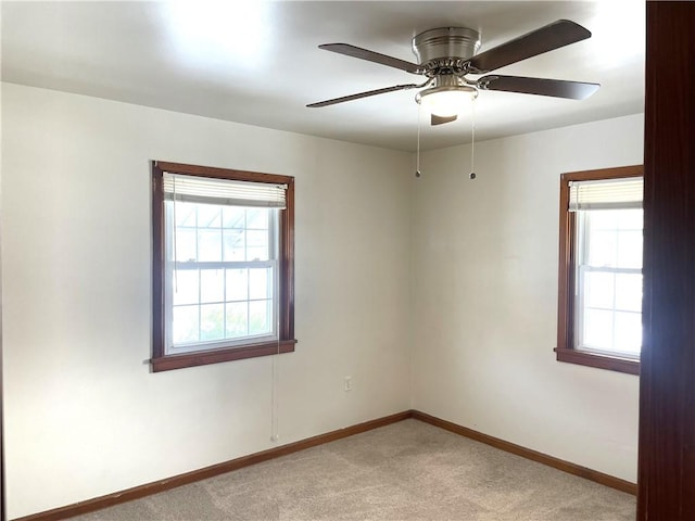 spare room featuring light colored carpet and ceiling fan