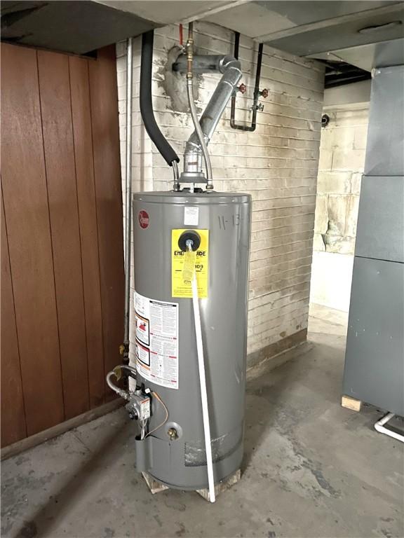 utility room with heating unit and water heater