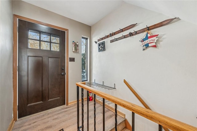 entryway with vaulted ceiling and light hardwood / wood-style floors