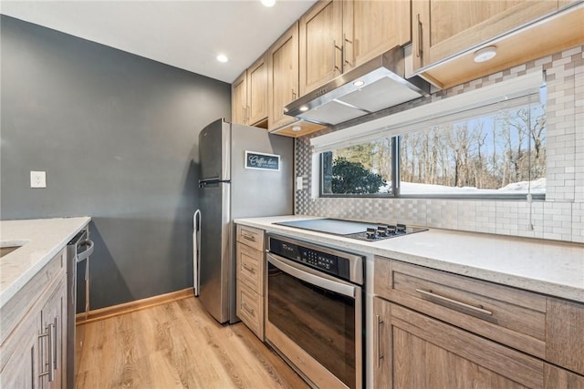 kitchen with stainless steel appliances, light hardwood / wood-style floors, light brown cabinets, and backsplash