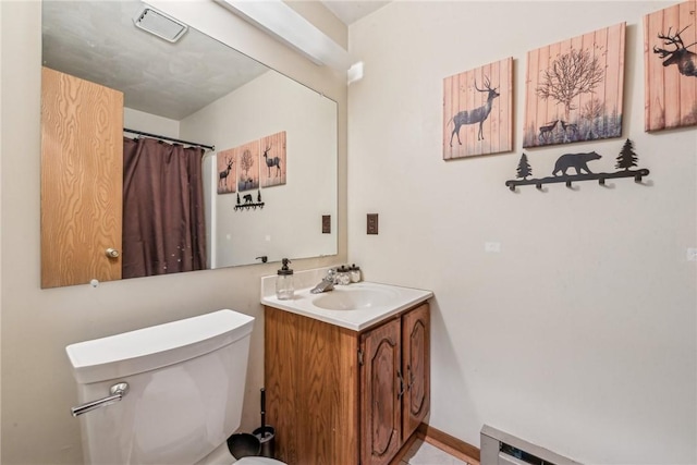 bathroom featuring vanity, toilet, and a baseboard heating unit