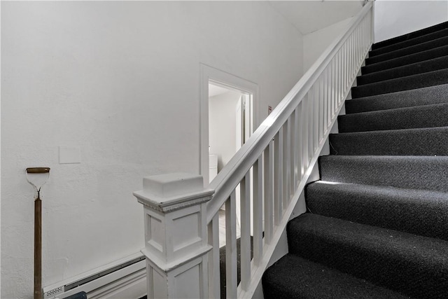 staircase with a baseboard heating unit