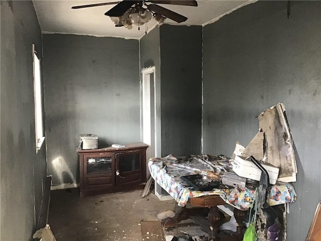 misc room with ceiling fan and concrete flooring