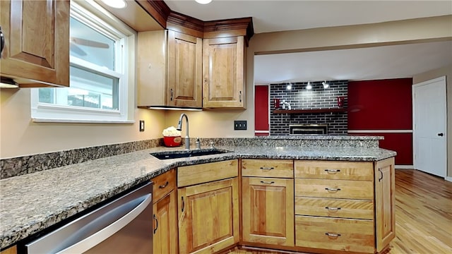 kitchen with dishwasher, sink, light stone counters, and light hardwood / wood-style floors