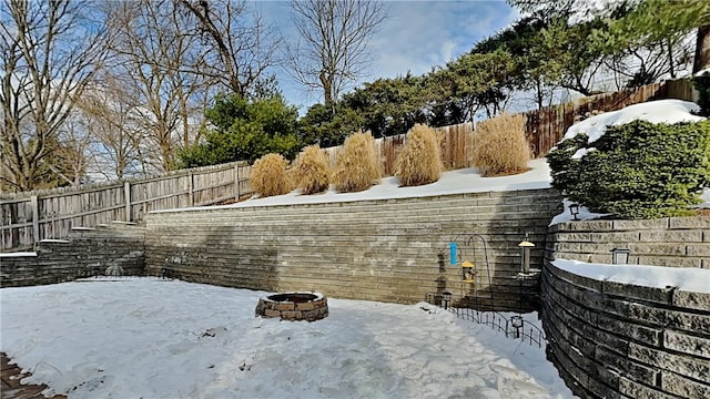 yard covered in snow with an outdoor fire pit