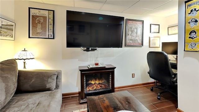 office area featuring a paneled ceiling and a fireplace